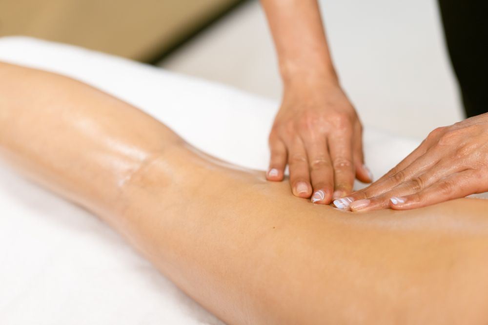 Skilled masseuse giving a hamstring massage to a woman