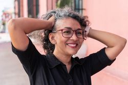 Gray-haired woman laughing outside