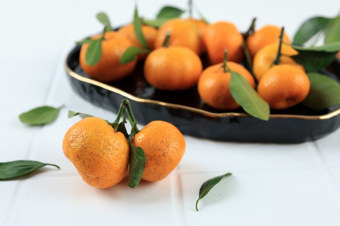 Fresh and Juicy Tangerines with Leaves on a Plain Background.