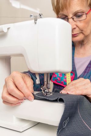Mature seamstress woman working on sewing machine