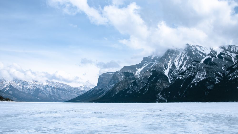 Lake Minnewanka near snow covered mountains in Banff National Park in Canada