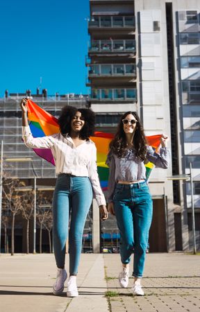 Happy female couple with LGBT flag