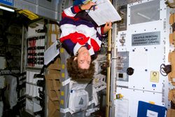 Mission specialist Ellen Ochoa beside the Volatile Removal Assembly Flight Experiment 5rZWl5