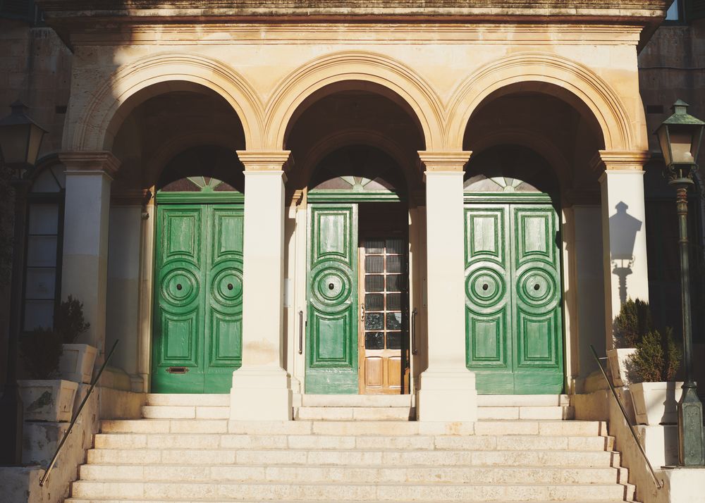 Three arches with green doors in the sun