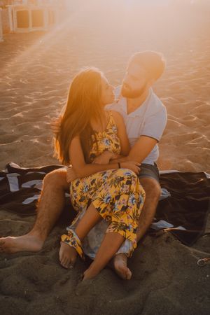 Tender couple embracing in sunlight on beach