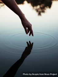 Person touching body of water with reflection 0vWBG5