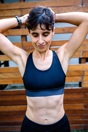 Sportswoman after training in front of a wooden background