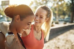Blonde woman smiling with her arm around her friend