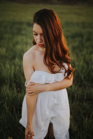 Barefoot woman with flowers in meadow