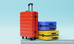 Three multi-colored hard shell roller suitcases on light yellow background bGkwVb
