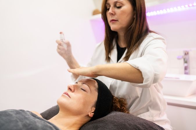 Woman receiving facial treatment in spa
