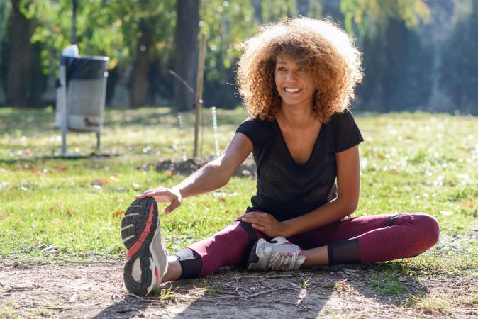 Happy woman stretching legs outside