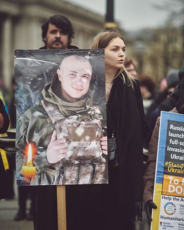 London, England, United Kingdom - March 5 2022: Woman holding sign of soldier with candle