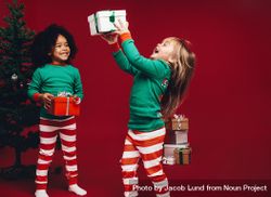 Little girls having fun playing with holiday gift boxes bEzYV0