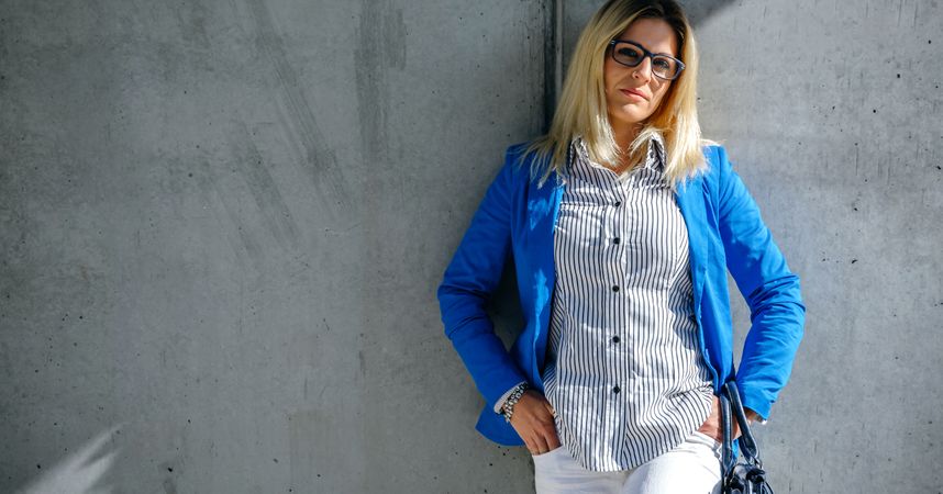 Businesswoman posing on concrete wall