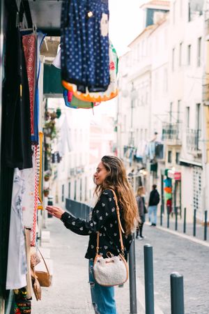 woman exploring street stall with clothes
