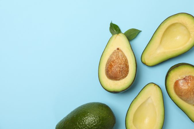 Ripe fresh avocado on blue background, top view