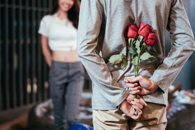 Asian man hiding roses to surprise his girlfriend on Valentine's day