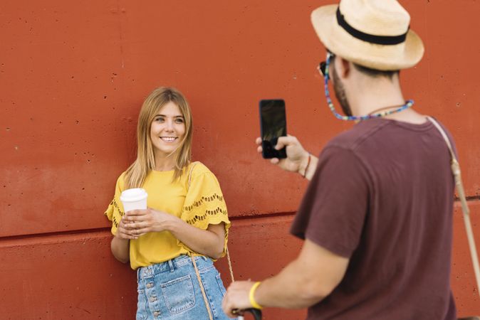 Young woman posing with coffee for man