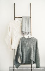 Woolen sweaters, grey scarf on modern garment rack 5lgKM0