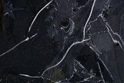 Fragment of thin ice on dark frozen river