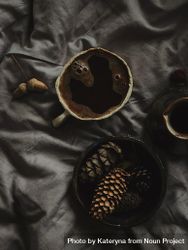 Top view of Turkish coffee surrounded by pine cones on grey sheets 4Oedo0