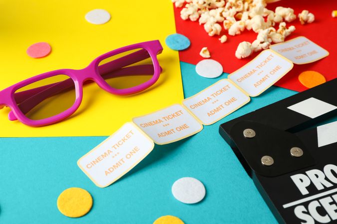 Composition with movie watching accessories on multicolor background, close up