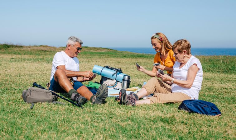 Happy family playing card game during a picnic near the ocean