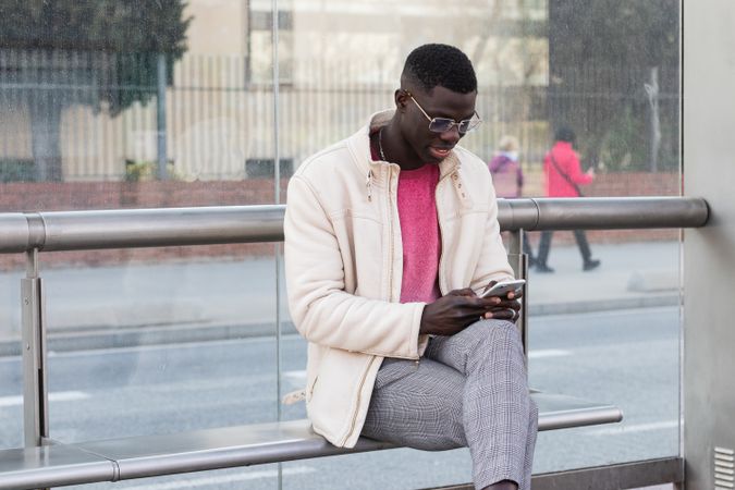 Black businessman chatting on smartphone on city street