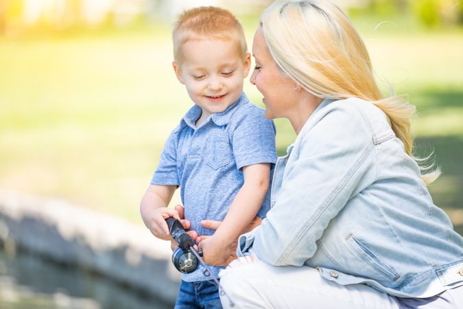 Young Mother and Son Having Fun Fishing At The Lake