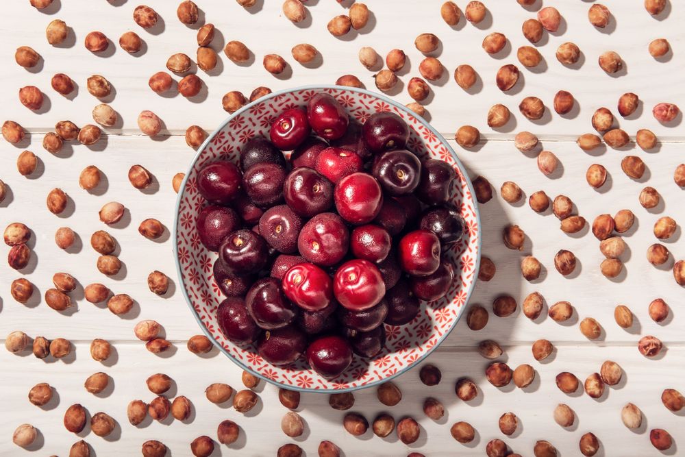 Fresh sweet cherries in bowl and cherry seeds