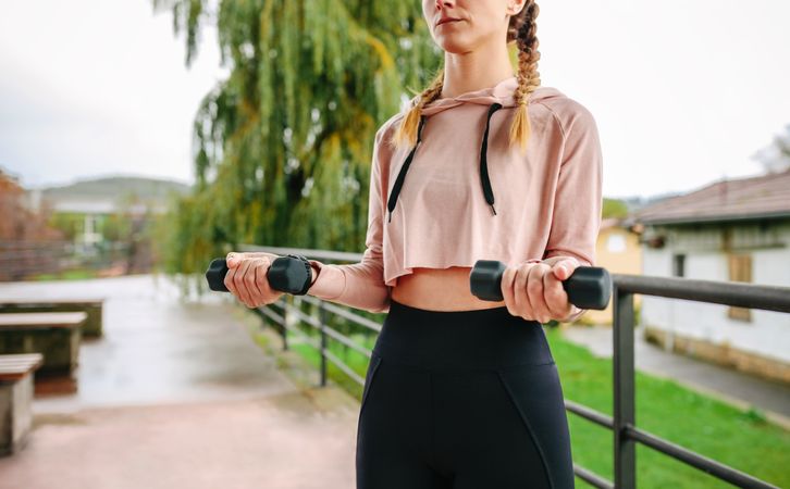 Young woman training with dumbbells