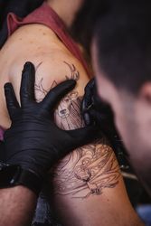 Master doing tattoo on forearm of male customer