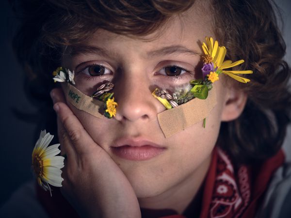 Calm boy with flowers on face