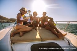 Group of happy young people sitting on yacht deck sailing in the sea 5loOM0