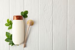 Natural hair care. Blank shampoo bottle and natural ingredients on wooden background