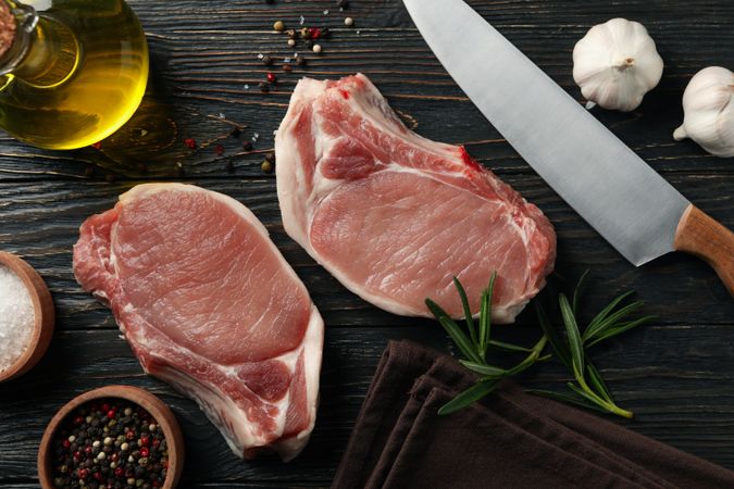 Composition with raw meat for steak and ingredients on wooden background