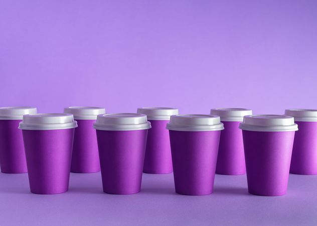 Disposable coffee cups on purple background