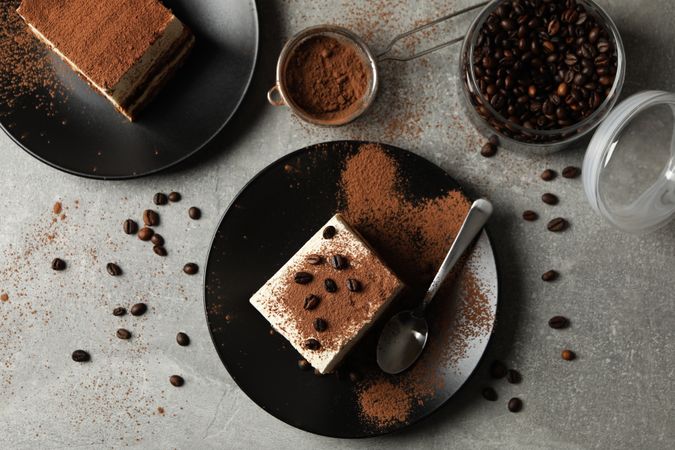 Composition with tasty tiramisu and coffee beans on gray background