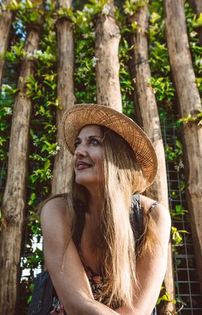 Smiling woman in straw hat looking away