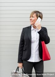Businesswoman in chic suit speaking on cell phone 4Byr35