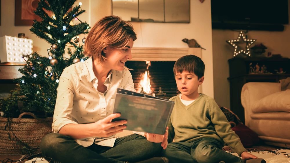 Mother reading book with son on Christmas eve