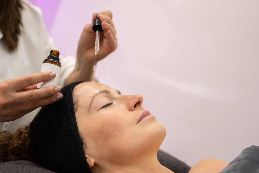 Side view of client with eyes closed having product dripped on forehead