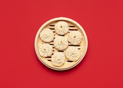 Raw baozi dumplings in a bamboo steamer, top view