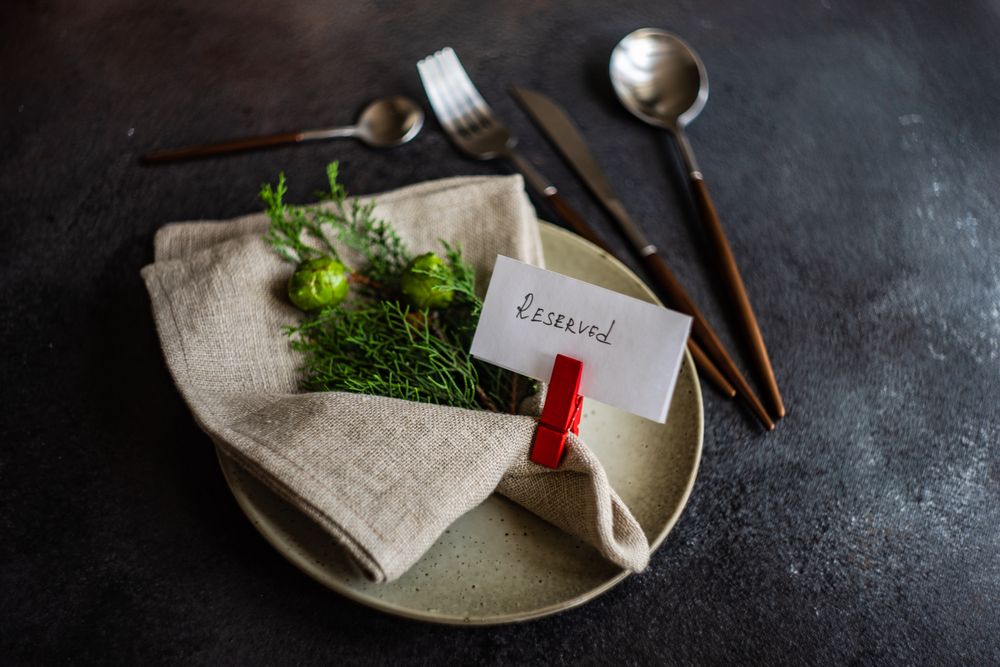 Christmas holiday concept of beige plate, branch and reserved card
