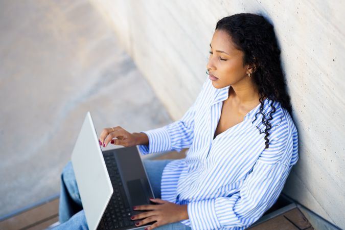 A Focused Young Woman is Quite Intently Working on Her Laptop While Enjoying the Outdoors