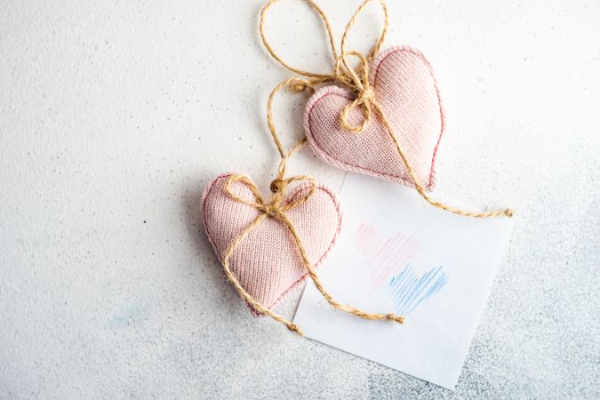 Valentine Day holiday card concept with felt pink heart decorations and heart drawing