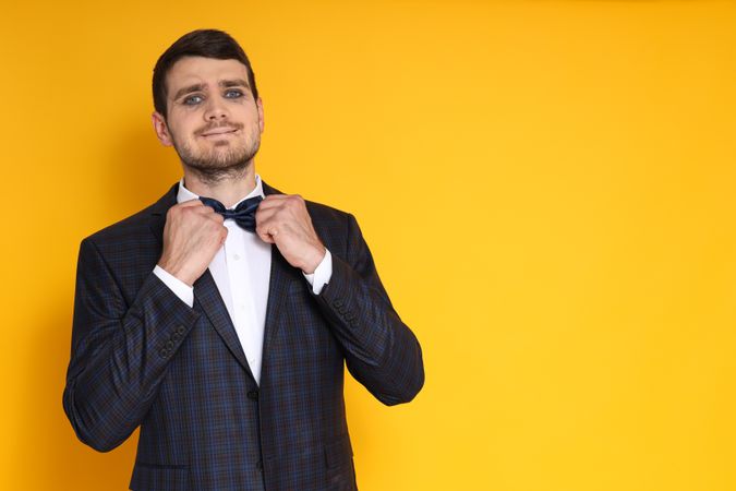 A man in a business suit with zombie makeup on a yellow background, cheerful