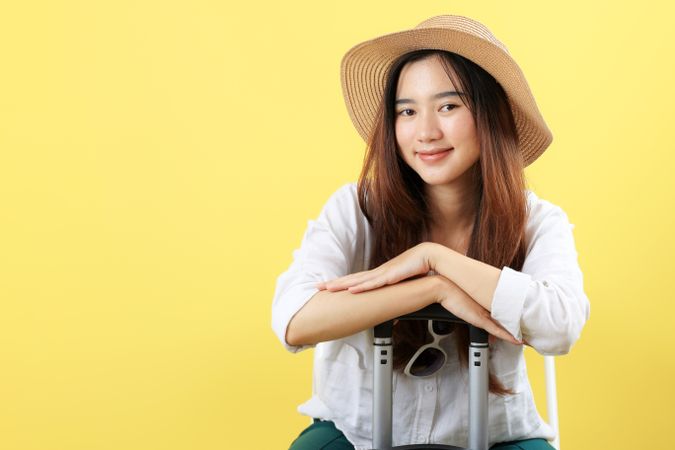 Happy Smiling Young Asian Woman Tourist in Summer Hat and Sun Glasses with Suitcase