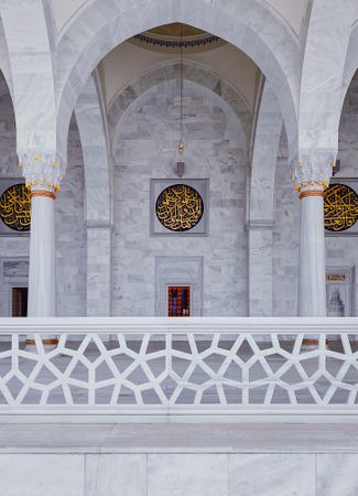 Marble wall in mosque with gold Arabic writing